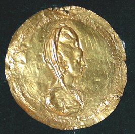 Disco de oro repujado con busto de dama