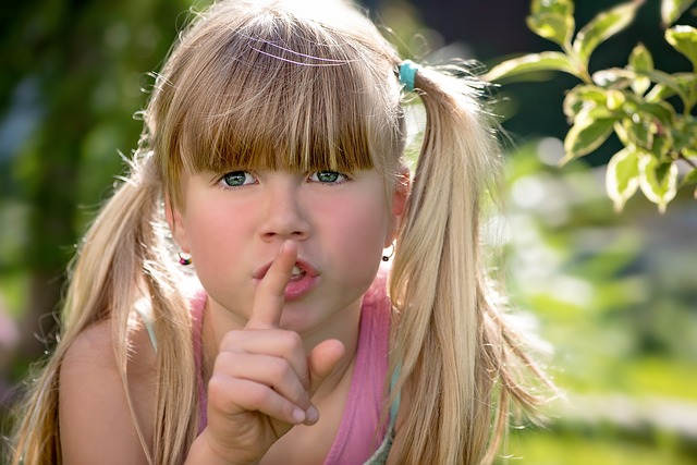 Foto de niña pidiendo silencio con el dedo