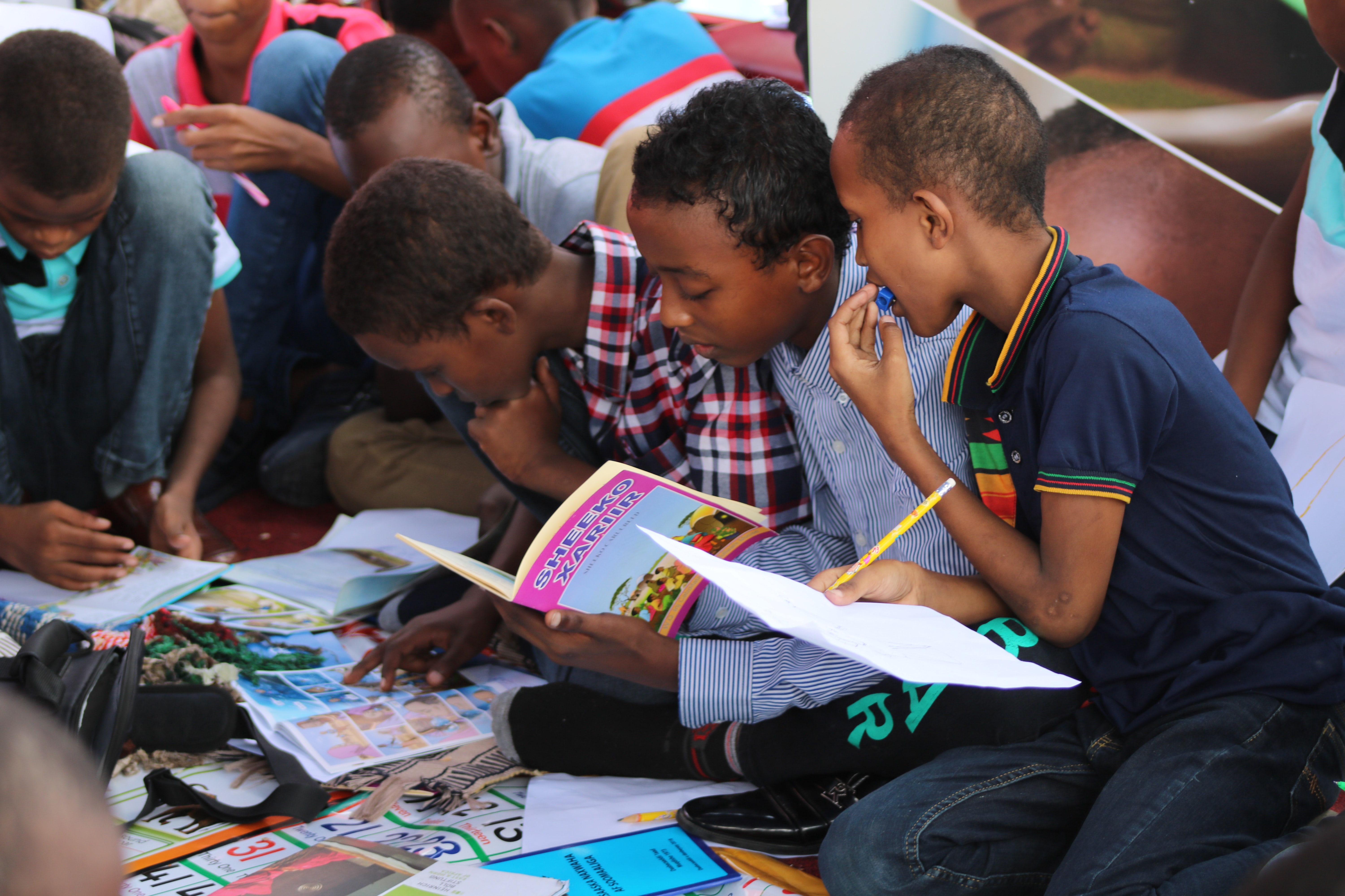 Fotografía de niños con libros leyendo y escribiendo