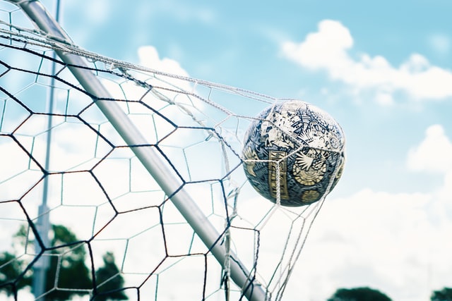 Imagen de un balón golpeando la red de una portería.