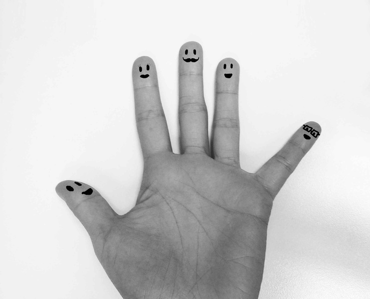 Palma de la mano en blanco y negro con emoticonos en las yemas