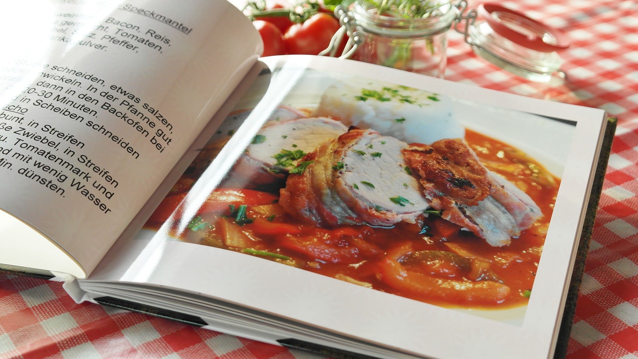 Libro de cocina, Recetas y Comida Fotografía a color de un libro de recetas abierto sobre una mesa de cocina. El libro parece estar en alemán.