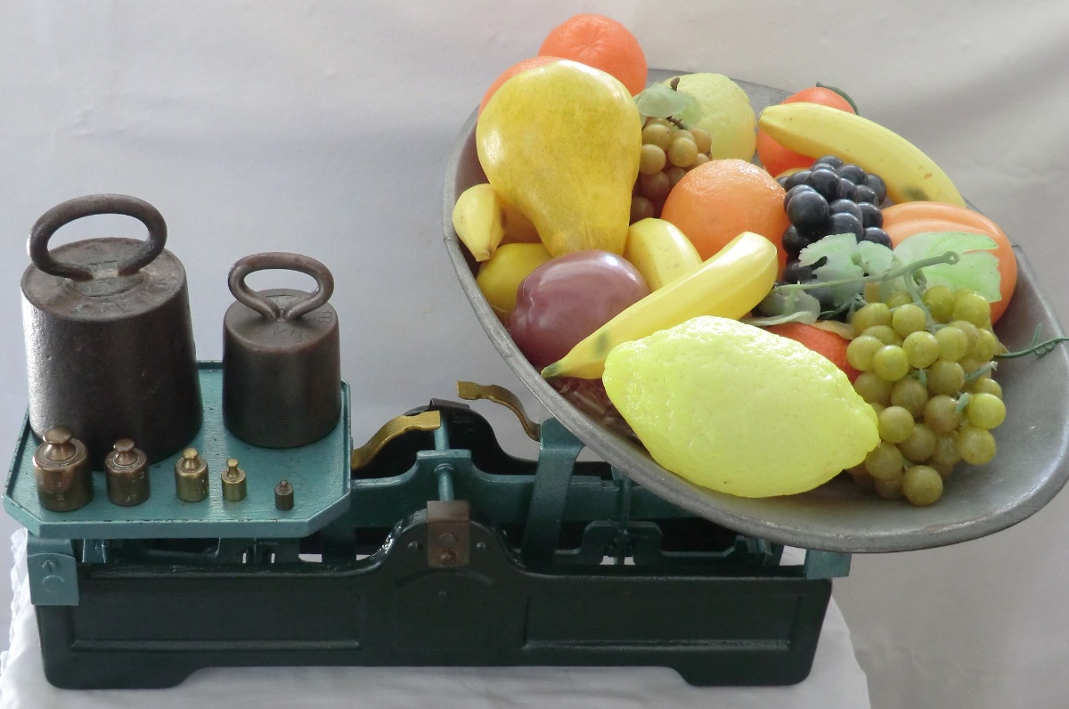 Balanza Balanza con pesas en un lado y frutas en el otro