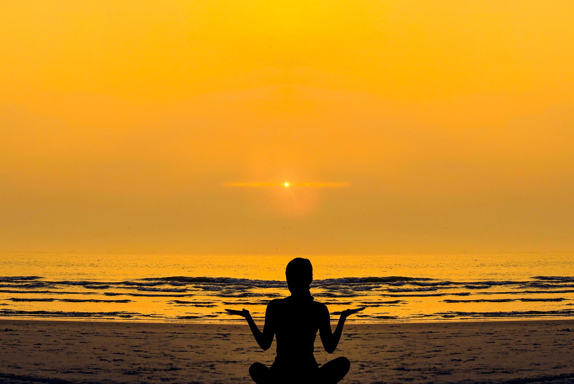 Persona haciendo yoga en la playa